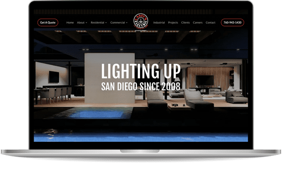 lapmock-casey Laptop screen displaying a website with a modern interior design image and text, "Lighting Up San Diego Since 2008." The website features navigation links including About, Residential, Commercial, and more.
